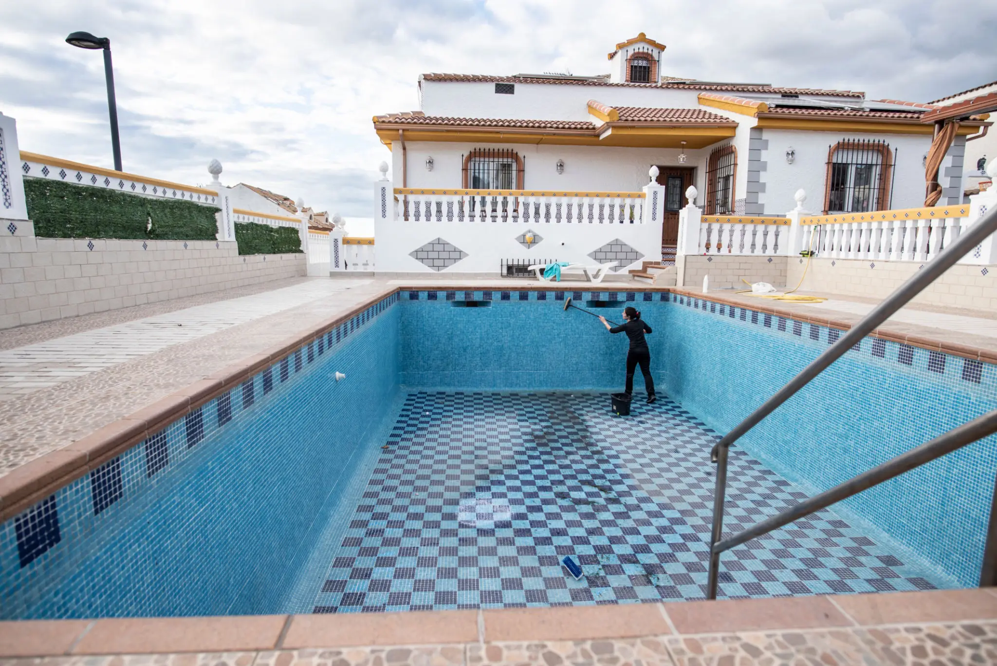Person cleaning empty swimming pool